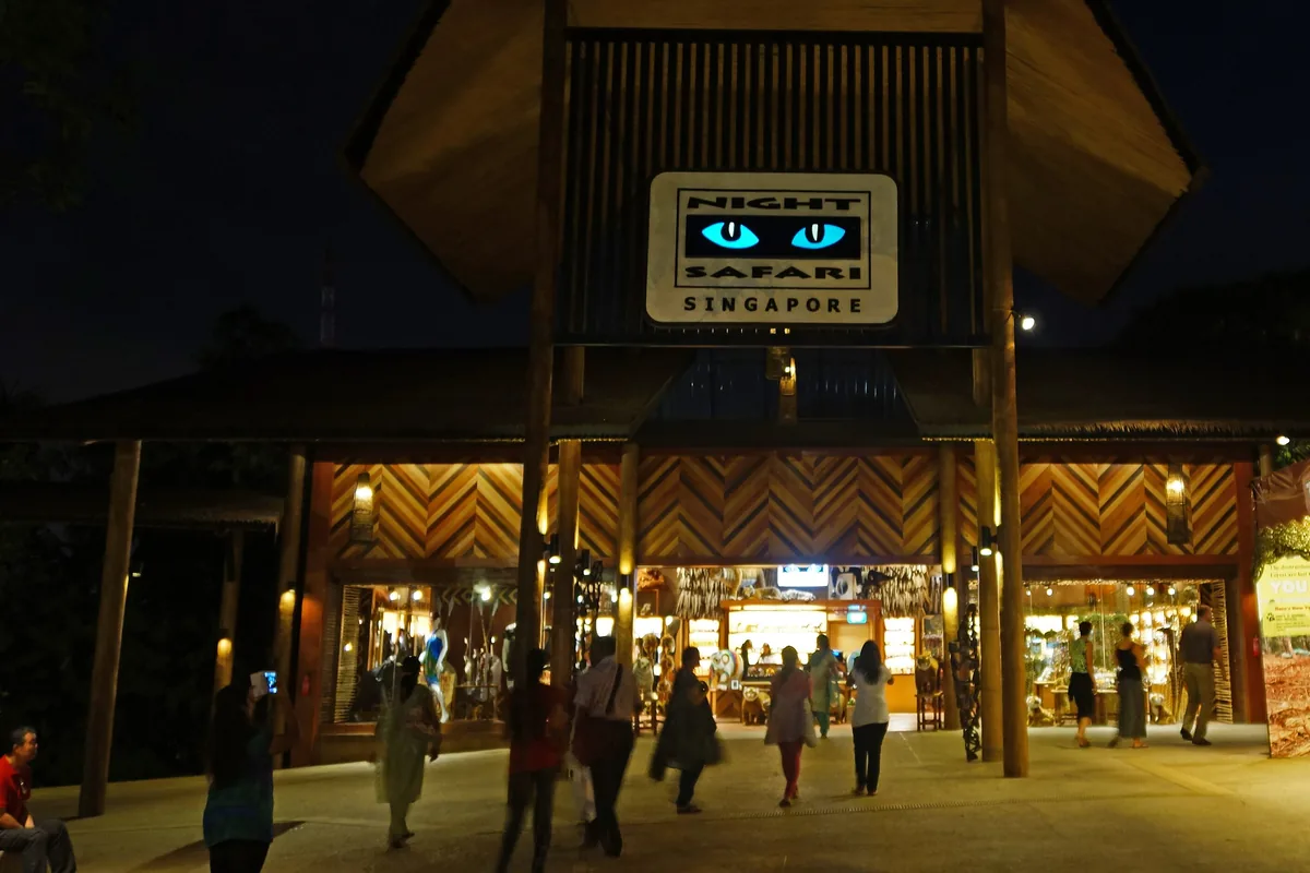 The entrance of the Night Safari with a lit pavilion roof and a night sky above
